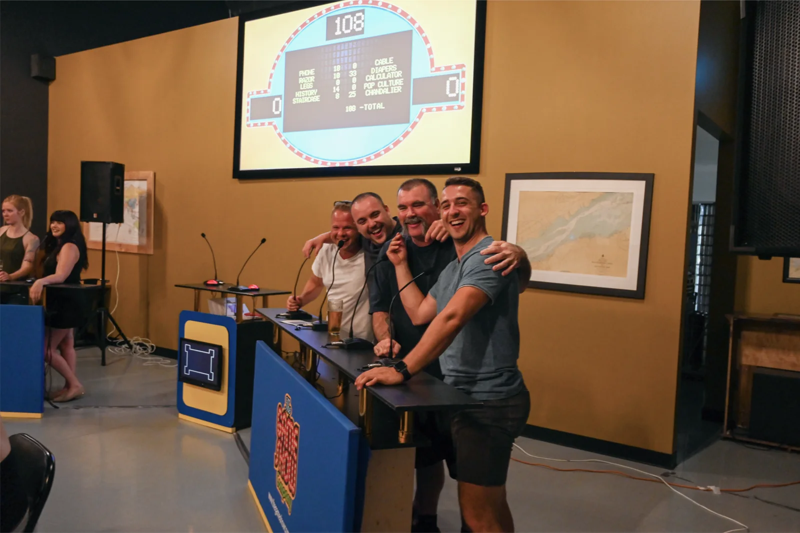 Contestants laughing together at a live game show